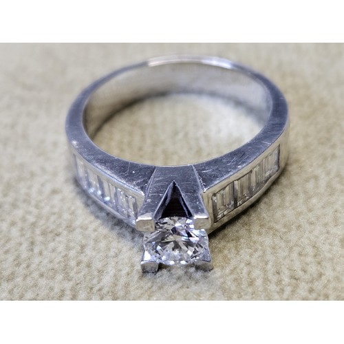 422 - An 18ct White Gold and Diamond Ring with a single round brilliant cut Diamond supported by four bagu... 