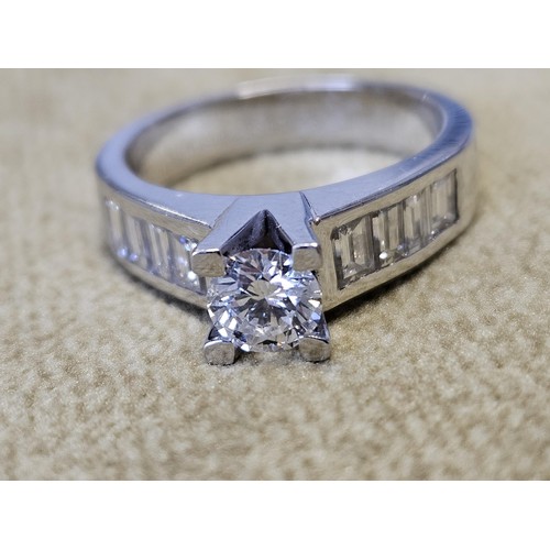 422 - An 18ct White Gold and Diamond Ring with a single round brilliant cut Diamond supported by four bagu... 