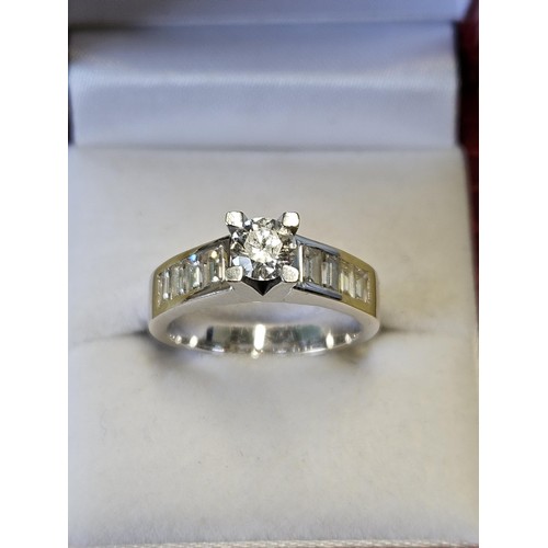 422 - An 18ct White Gold and Diamond Ring with a single round brilliant cut Diamond supported by four bagu... 