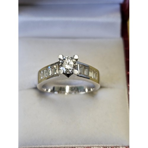 422 - An 18ct White Gold and Diamond Ring with a single round brilliant cut Diamond supported by four bagu... 