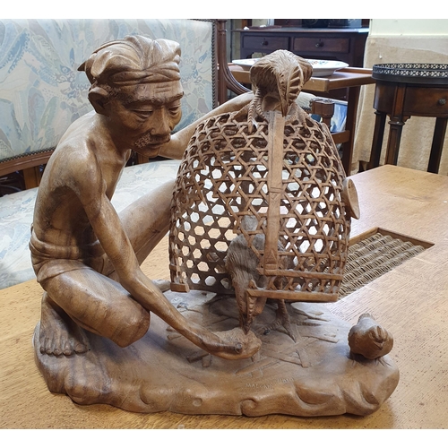 23 - A good Oriental Hardwood figure of a Man catching a cockerel. W42 x D 28 x H 36 cm approx.