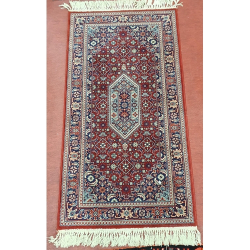 538 - A good Persian burgundy ground Rug with unique central design and multi borders and tassel ends, in ... 