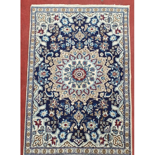 547 - A Rich Blue ground fine hand woven Persian Nian wool part silk Rug with a lozenge medallion design, ... 