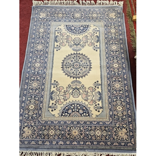 331 - A light mauve Rug with repeating central medallion design and multi borders. 210 x 140 cm approx.