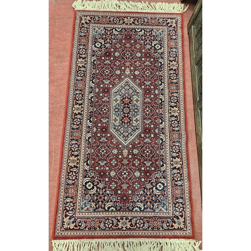 538 - A good Persian burgundy ground Rug with unique central design and multi borders and tassel ends, in ... 