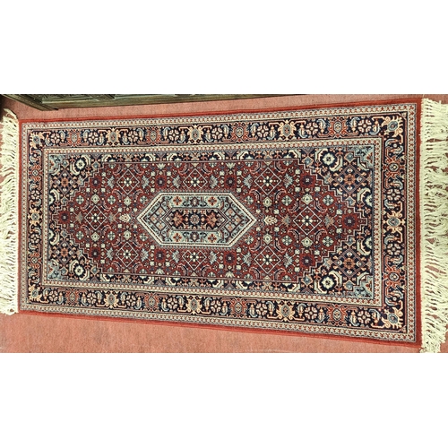 538 - A good Persian burgundy ground Rug with unique central design and multi borders and tassel ends, in ... 