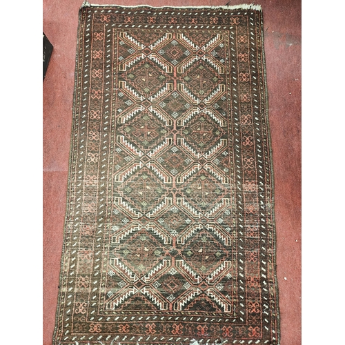 552 - A burgundy ground Persian Rug with repeating central medallion design and multi borders. 143 x 84 cm... 