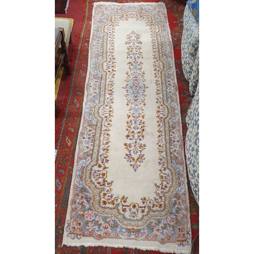 500 - A Vintage hand woven Persian Kerman Cream ground Runner with floral design. 240 x 78 approx.