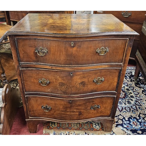 560A - An early 20th Century Walnut miniature chest of Drawers with a serpentine outline.