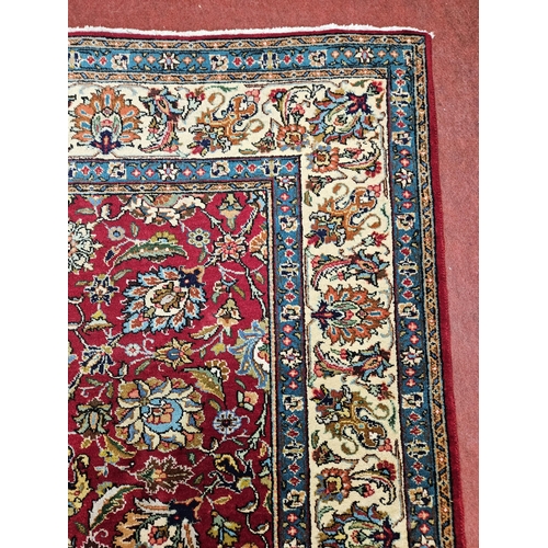 958 - A Red ground Persian Tabriz Carpet with a hand woven and a unique all over floral design nd surround... 