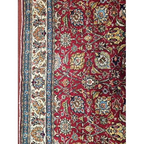 958 - A Red ground Persian Tabriz Carpet with a hand woven and a unique all over floral design nd surround... 