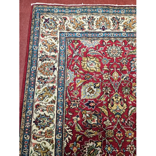 958 - A Red ground Persian Tabriz Carpet with a hand woven and a unique all over floral design nd surround... 