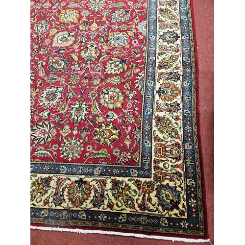 958 - A Red ground Persian Tabriz Carpet with a hand woven and a unique all over floral design nd surround... 