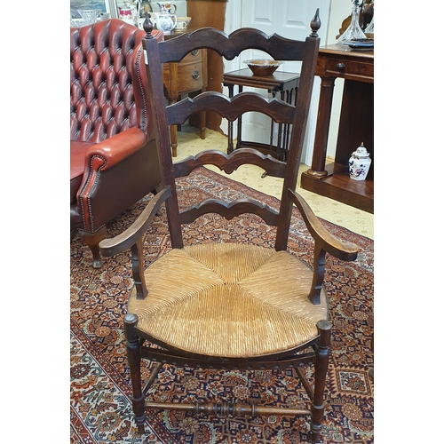 602 - A good provincial Elm ladder back Armchair with rush seat. W 66 x SH 42 x BH 118 cm approx.