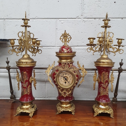 929 - A 20th Century Brass and Porcelain Garniture Set on red ground.