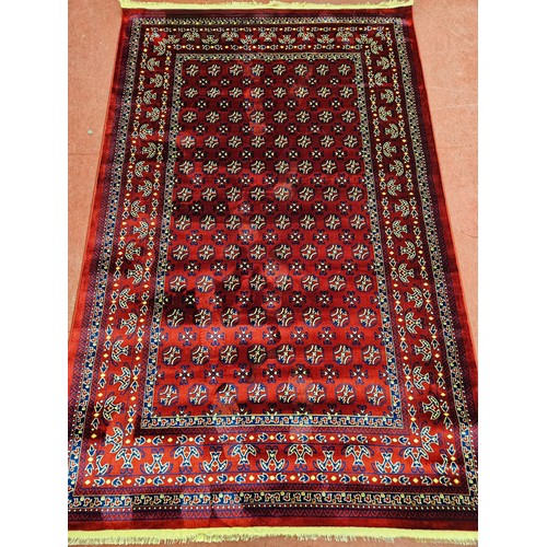 1425 - An as new red ground Turkish Soft Full Pile Carpet with central repeated panel design surrounded by ... 