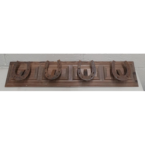 27 - A retro early 20th Century Walnut backed coat Rack with horseshoe Hangers, 71cm wide.