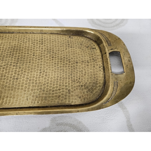 196 - An unusual 19th early 20th Century hammered Brass centre Tray in oblong form, 77 x 22 cms approx.