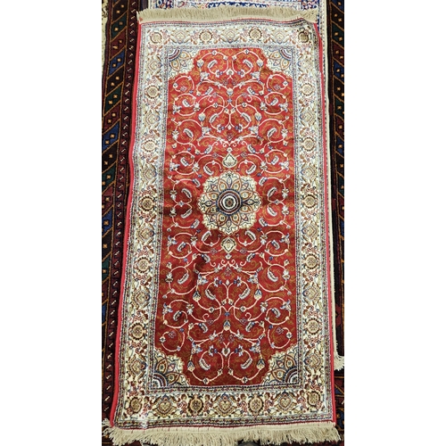 715 - A rich red ground full pile Cashmere design Rug with a traditional medallion design.
L 149 x W 68 cm... 