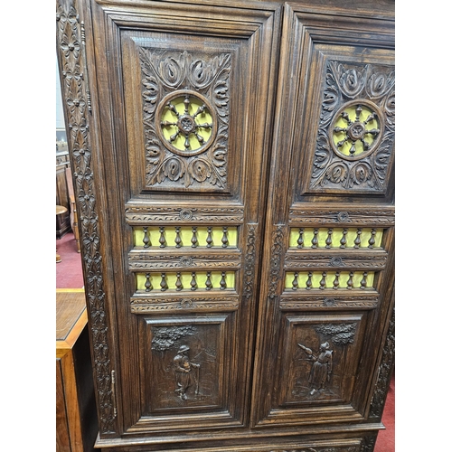 26 - A Fabulous Oak two door Cabinet/Wardrobe with highly carved twin doors backed with pleated material.... 