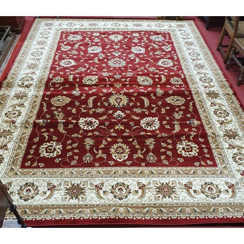 723 - A large Red ground full pile Turkish Carpet with an all over floral pattern design and surrounding b... 