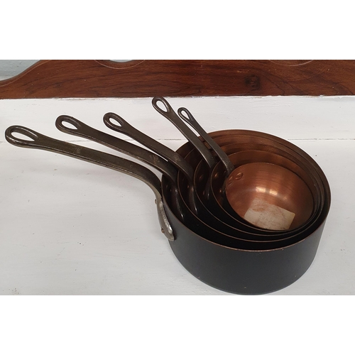 98 - A good graduated set of Copper Saucepans with cast iron handles.