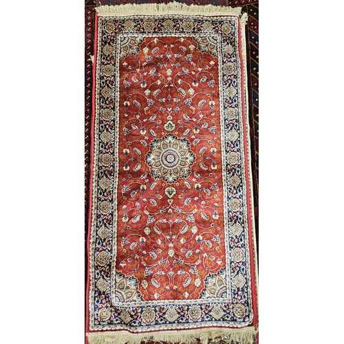 716 - A rich Red ground full pile Cashmere design Rug with a traditional medallion design.
L 149 x W 68 cm... 