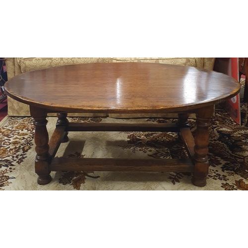 875 - A large heavy oval Oak Coffee Table on turned supports and stretcher base. 122 x 87 x H 48 cm approx... 