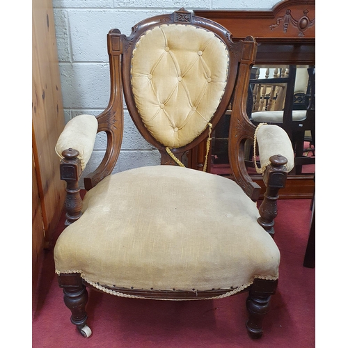 746 - A Victorian Walnut showframe Armchair with shield back on turned supports and brass ceramic castors.... 