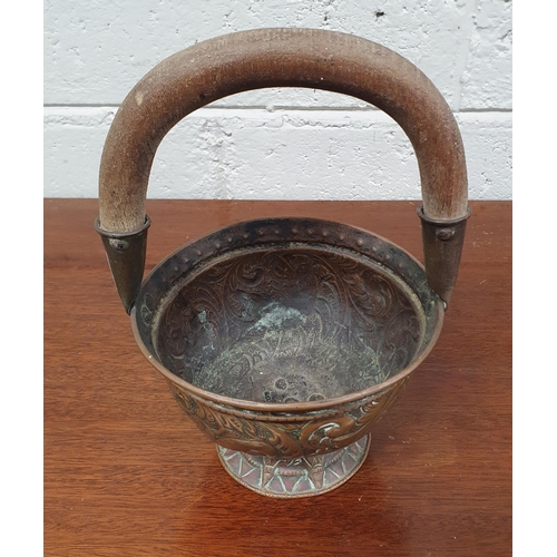 57 - A very interesting Arts and Crafts Copper Basket with timber handle embossed with foliage, birds and... 