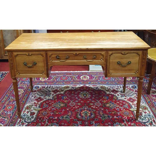 598 - A late 19th/early 20th Century Walnut Kneehole Writing Table on turned supports and carved front. W ... 