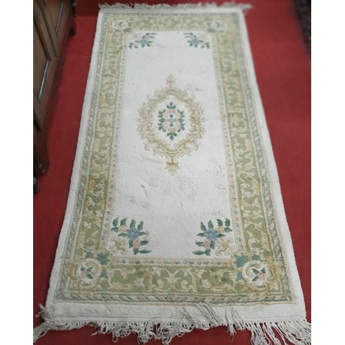 384 - A cream ground Rug with with multi borders and central medallion design. 205 x 94 cm approx.