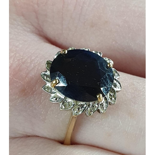 356 - A large Sapphire Ring, surrounded with Diamonds set in Gold, size S1/2.