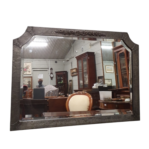 437 - A good Arts and Crafts/ Art Nouveau panel beaten Metal Mirror with beveled mirrored glass.
60 x 85 c... 