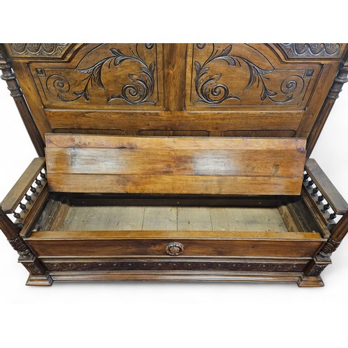 34 - A Large Walnut Hall Bench with lift up seat and highly carved outline. 166 x D 56 x H 155 cm approx.