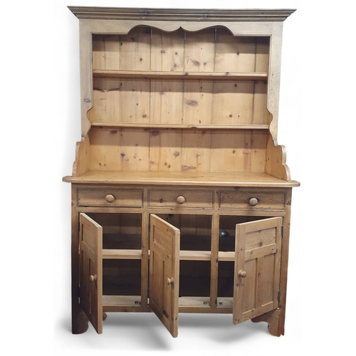 15 - A large stripped Pine Dresser of good quality with a triple panel door base.
W 136 x D 56 x H 196 cm... 