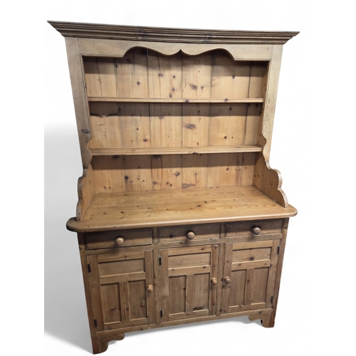 15 - A large stripped Pine Dresser of good quality with a triple panel door base.
W 136 x D 56 x H 196 cm... 