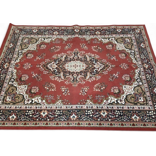 427 - A large European red ground Rug with central floral motif floral spandrels and multiple floral borde... 
