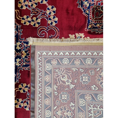435 - A red ground Turkish Soft Full Pile Carpet with central medallion design surrounded by borders and b... 