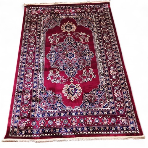 435 - A red ground Turkish Soft Full Pile Carpet with central medallion design surrounded by borders and b... 