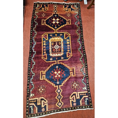 450 - A handwoven Persian Shiraz village Rug with a medallion design. 116 x 242 cm approx.