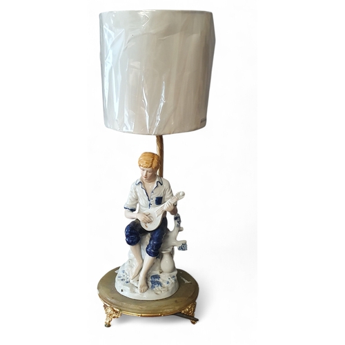 336 - A really nice Porcelain and Onyx Table Lamp depicting a boy sitting on a tree stump playing a lute o... 