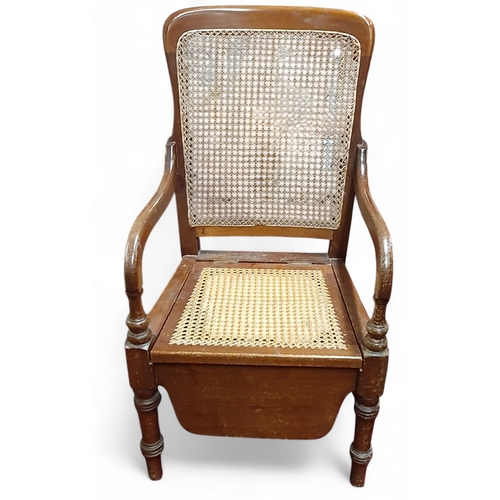466 - A late 19th Century Mahogany show framed Commode Chair with cane back and seat, on turned supports. ... 