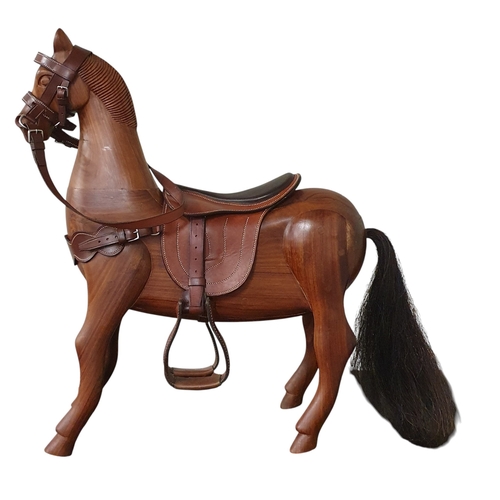 278 - A 20th Century Walnut Horse with leather saddle and harness. L 56 x H 73 cm approx.