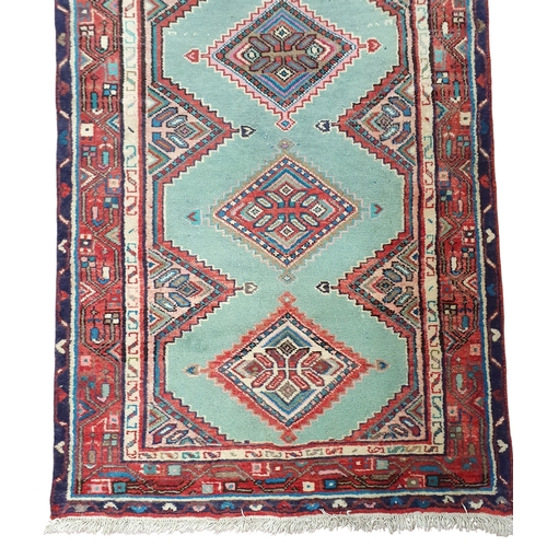 219 - A Persian red and green ground Runner with repeating central medallion design and multi borders. 407... 