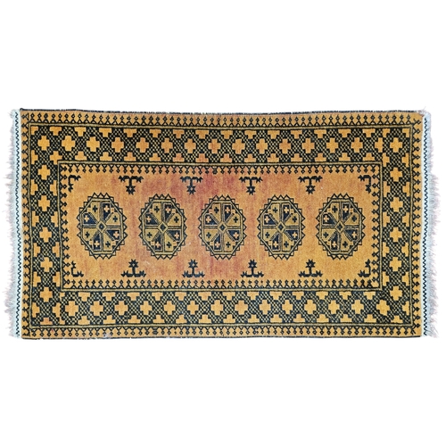 220 - A Persian Bukhara style Rug with a rust ground repeating central medallion design.
139 x 74 cm appro... 