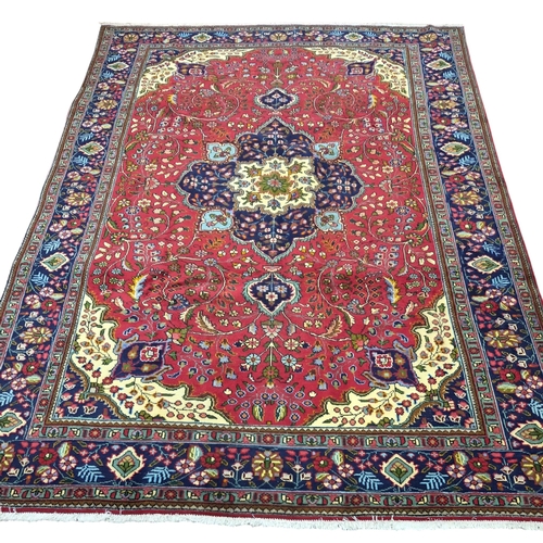 438 - A multicoloured ground fine hand woven Persian Tabriz Carpet. 246 x 348 cm approx.