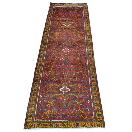 24 - A deep Red ground handwoven Persian Tabriz Runner with an all over floral pattern and small medallio... 