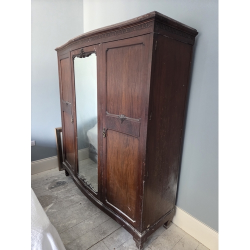 766 - An early 20th Century Mahogany three door Wardrobe with mirrored centre and serpentine outline.
W 17... 