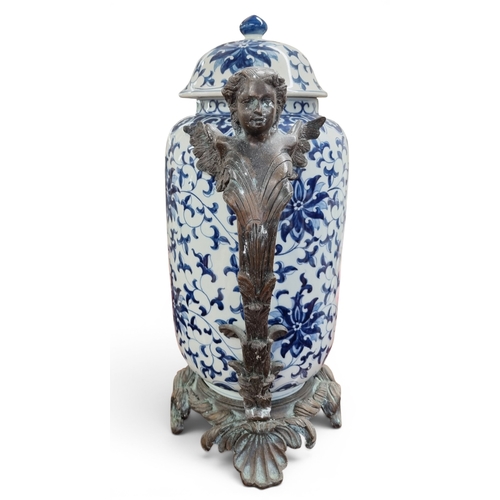 57 - A large Bronze and Ceramic Centrepiece depicting a blue and white central ginger jar held up by a pa... 